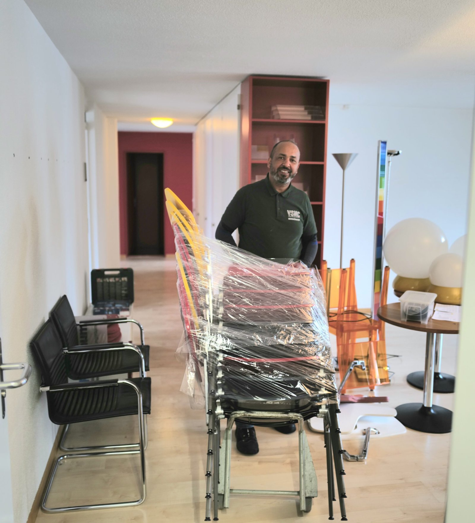 Mitarbeiter hinter verpackten Stühlen Mitarbeiter hinter verpackten Stühlen