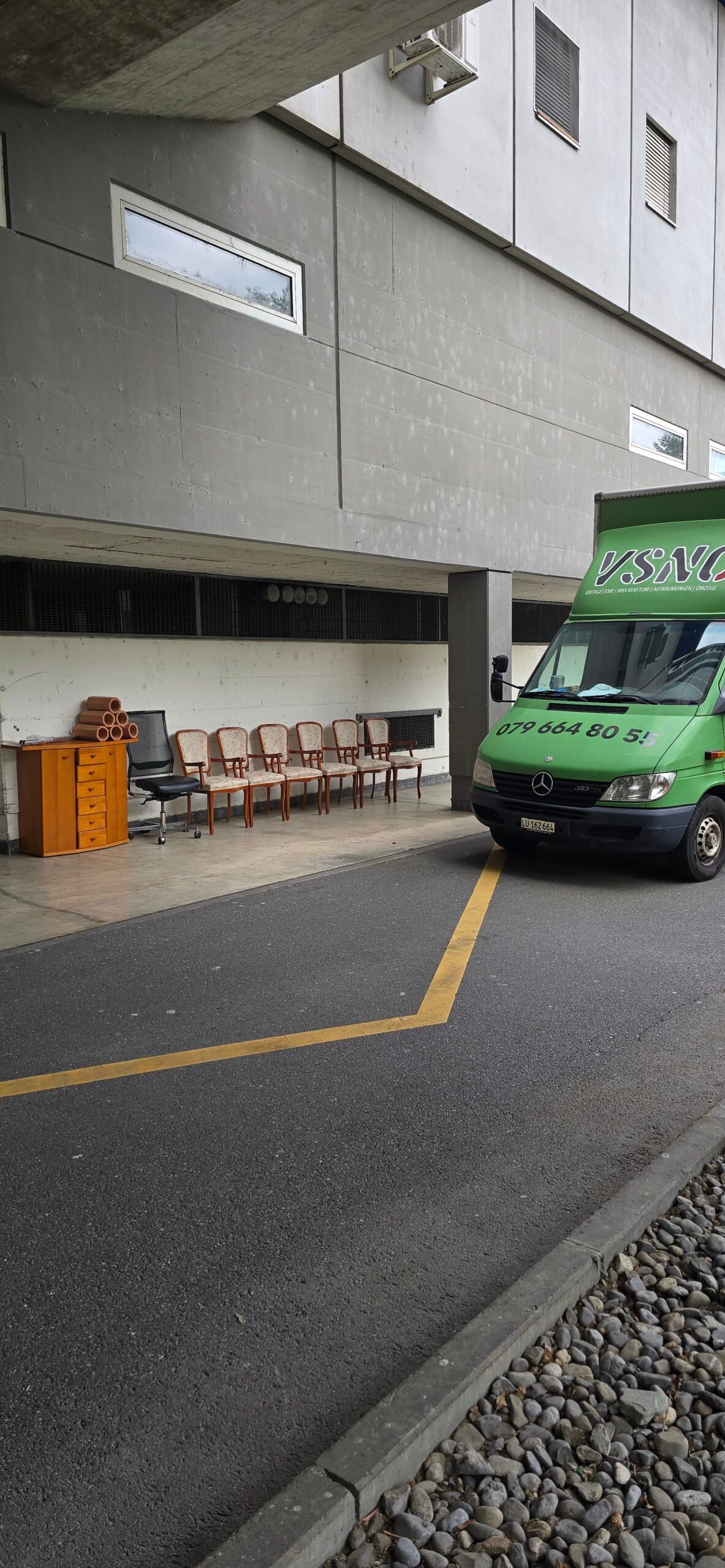 Stühle und Möbel neben einem grünen VSNC Transporter